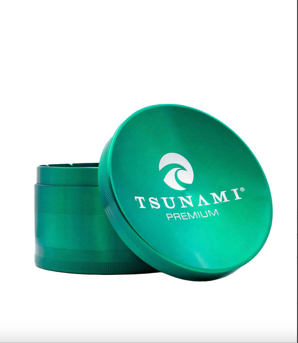 Side view of the Tsunami premium grinder showcasing its concave top assisting with moving your herb to be broken down consistently and made of durable metal with a chromium finish in a green.