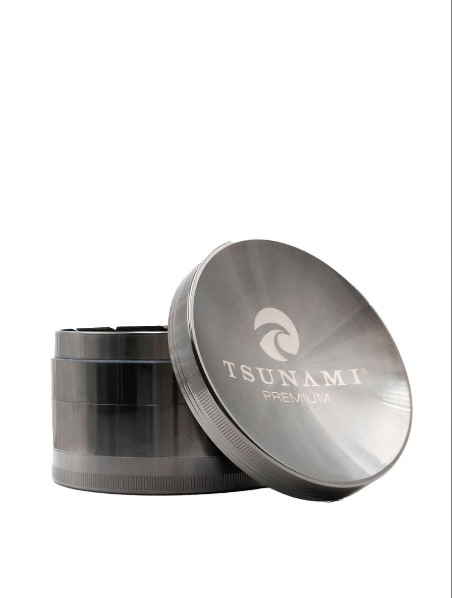Side view of the Tsunami premium grinder showcasing its concave top assisting with moving your herb to be broken down consistently and made of durable metal with a chromium finish in a dark grey gun metal.