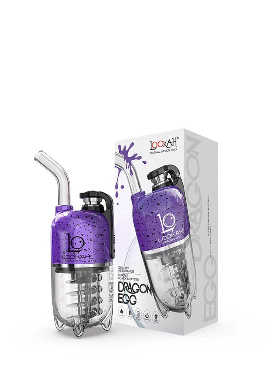 Angled overhead view of the Lookah Dragon Egg Electric Dab E-Rig in rich purple with intense black splatter styling. This capsule-style portable e-rig features a unique bottom-mounted water bubbler and a magnetic cap to deliver cool, smooth, and filtered concentrate hits on the go.