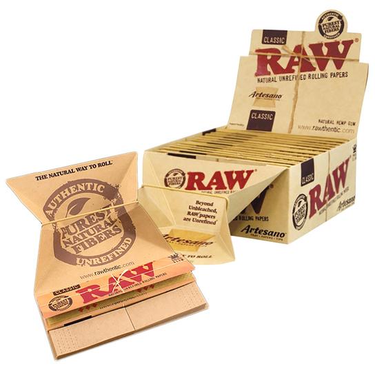 Angle view of packaging for RAW Classic Artesano King Size Slim Rolling Papers, displaying the product with a box, pack, and rolling paper trays. A premium rolling paper brand.