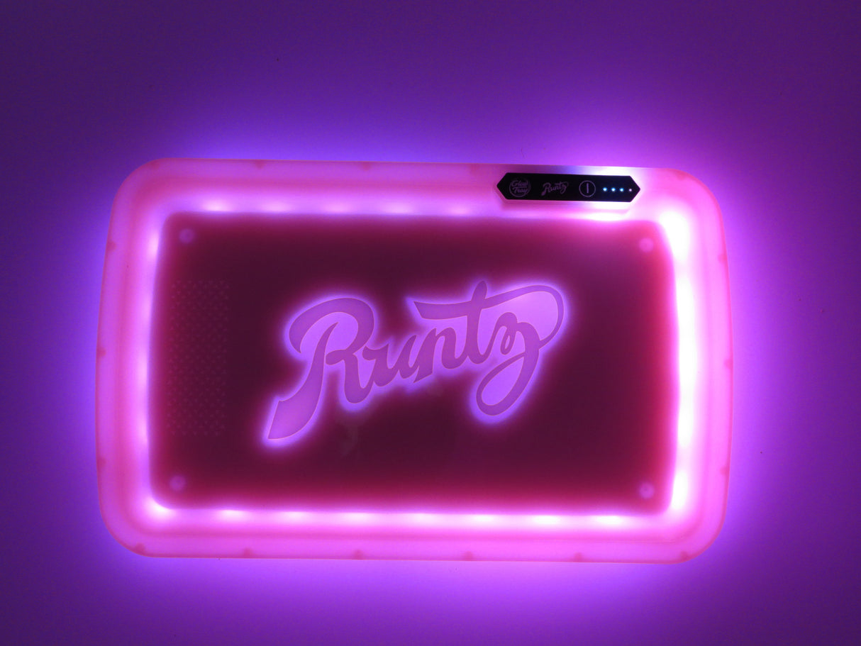 darkened view of the Runtz Pink LED rolling tray with its lights on. A novel rolling tray toy can use in the dark to roll your blunts.