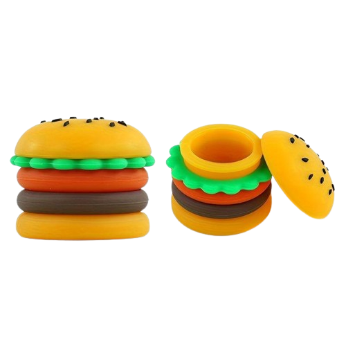 Angled overhead view of the Hamburger silicone wax containers in brown, green, yellow, and red. These 5ml food-themed, residue-repellent extract carriers feature removable modular rings and securely store semi-solid botanical materials.