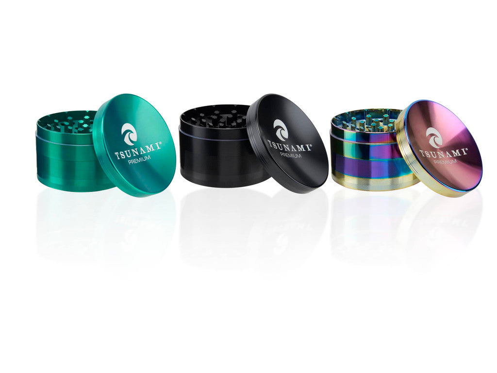 Front view of multiple Tsunami 100mm sunken top herb grinders arranged in a group to display a variety of metallic color options like green, black, and rainbow. Crafted from medical-grade aluminum, this oversized 4-inch accessory is built for ultimate durability and maximum yield.