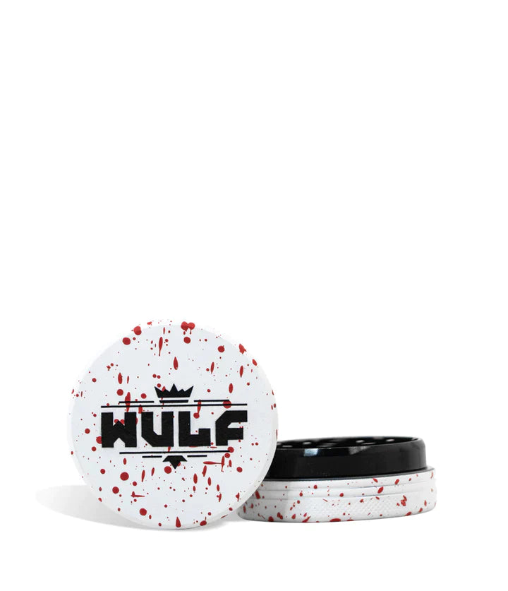 Front angled view of the Wulf Mods 2-Piece 50mm Spatter Aluminum Grinder in white with vibrant red paint splatter. This ultra-compact, travel-friendly magnetic herb grinder features a streamlined two-piece design to quickly and efficiently shred your botanical blends without any extra bulk.
