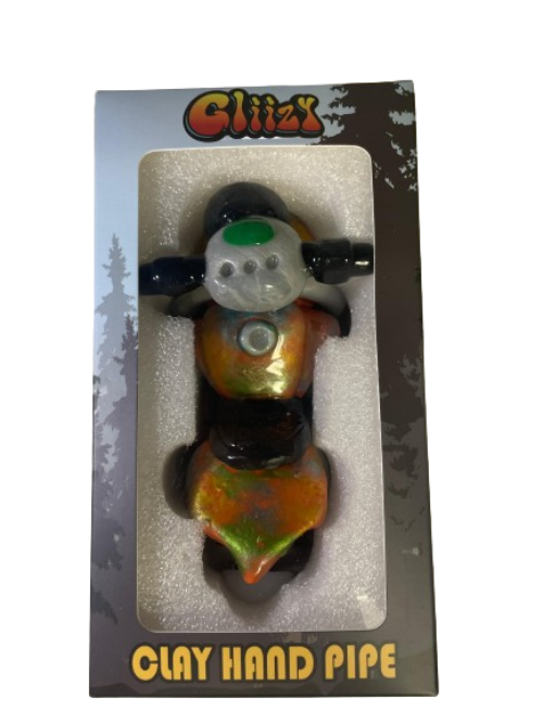 Angled profile view of the 5" Glizzy Clay Hand Pipe with a red accent. This novelty food-themed clay smoking instrument is designed to visually replicate a hot dog, featuring an integrated deep-dish bowl and side-carb.