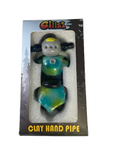 Angled profile view of the 5" Glizzy Clay Hand Pipe with a blue accent. This novelty food-themed clay smoking instrument is designed to visually replicate a hot dog, featuring an integrated deep-dish bowl and side-carb.