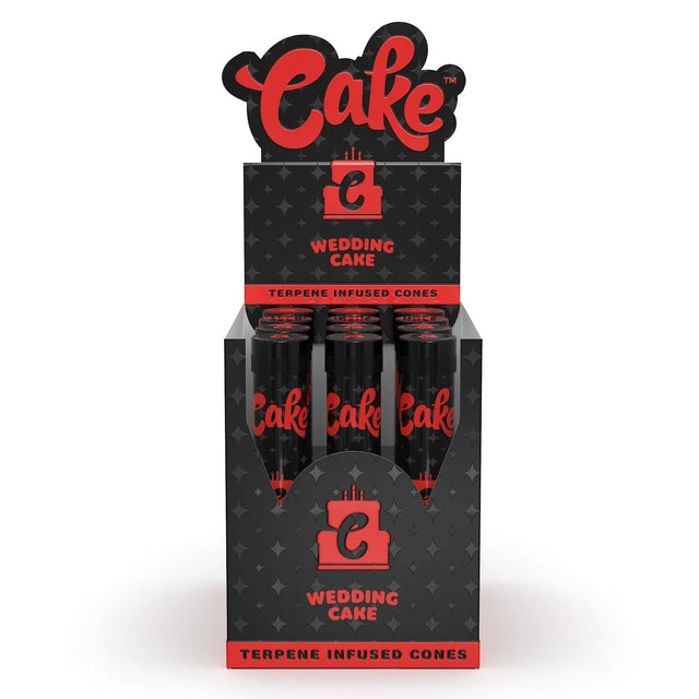 Front view of the Cake Terpene Infused Cones 12-count display carton in the white and gold Wedding Cake flavor. These ultra-thin pre-rolled paper wraps are physically saturated with natural botanical terpenes to introduce specific aromas and are housed inside rigid glass tubes.