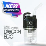 Front view of the Lookah Dragon Egg Electric Dab E-Rig in a matte black base with dynamic green splatter accents. This capsule-style portable e-rig features a unique bottom-mounted water bubbler and a magnetic cap to deliver cool, smooth, and filtered concentrate hits on the go.