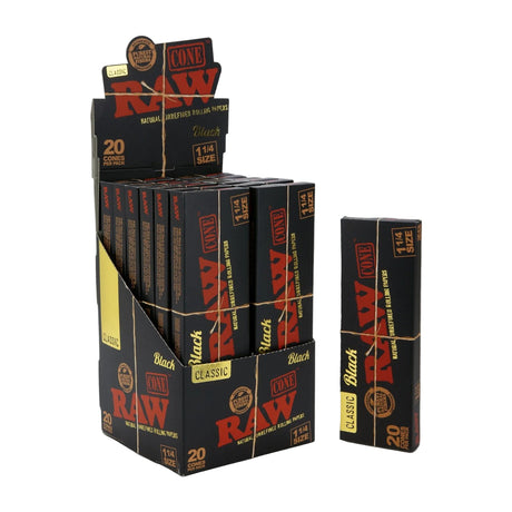 Angled overhead view of the RAW Black Pre-Rolled Cones 1 1/4 Size 12-count display box in black and gold. Showcasing the opened retail display, this box neatly presents twelve individual 20-packs for easy countertop purchasing.