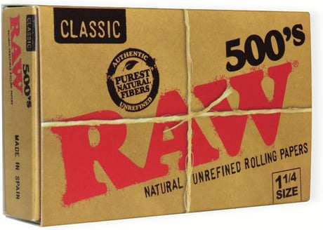 Front flat lay view of a single RAW Classic 1 1/4 500s rolling paper box in natural tan with clean red and black lettering. This large, durable protective box houses a massive supply of 500 unbleached, translucent papers for heavy consumers and dedicated rollers.