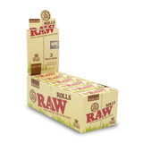 Front angled view of the RAW Classic King Size Wide 3-Meter Rolls 12-count display box in natural kraft brown packaging with red branding. This retail-ready carton provides smoke shops with an attractive countertop presentation for these customizable, unbleached rolling papers.