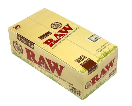 Front angled view of the RAW Organic Hemp Single Wide Double Window 25-count display box in natural light brown packaging with green branding. This retail-ready display box provides smoke shops with an eye-catching countertop presentation for these bulk-capacity organic hemp rolling papers.