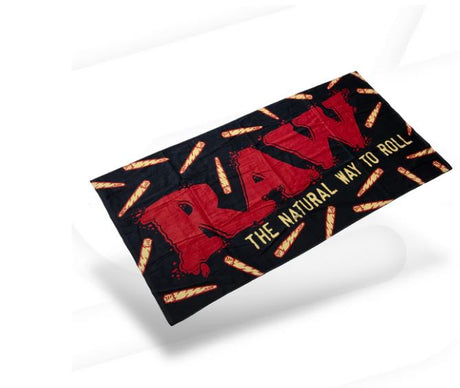 Front view of the RAW Stash Pocket Beach Towel in bold black and red. This 100% cotton large-format fabric features an integrated Velcro-sealed stash pocket to safely conceal smoking hardware and unrefined materials from the elements.