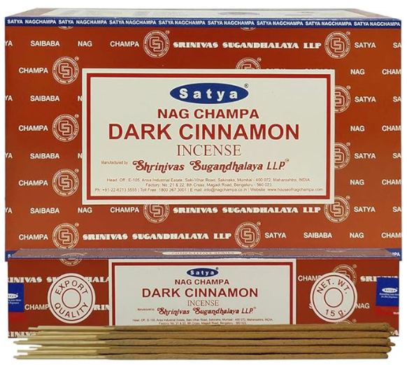 Front view of the Satya Incense 15g 12-Count Display box in the Dark Cinnamon variant featuring brown and cream tones. This combustible agarbatti stick display unit is ideal for vertical counter placement to drive impulse checkout transactions.