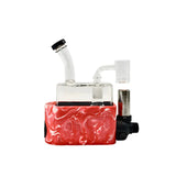Front view of the Stache Rig in One mechanical dab rig with a pink silicone base sleeve. This all-in-one setup integrates a refillable butane torch directly below a quartz banger for convenient, cordless concentrate dabbing.