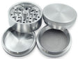 Angled overhead view of the 32mm aluminum grinder in black separated into its four core components. The versatile modular design features a magnetic lid, sharp grinding chamber, fine mesh pollen screen, and a bottom kief catcher to maximize your dry herb yield.