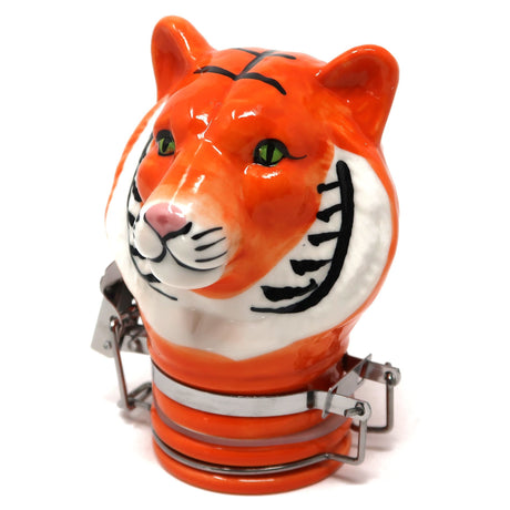 angled view of the contained art 100ml ceramic orange tiger jar. A bright ceramic jar with a stylized design with a rugged metal frame of the jar hinge.