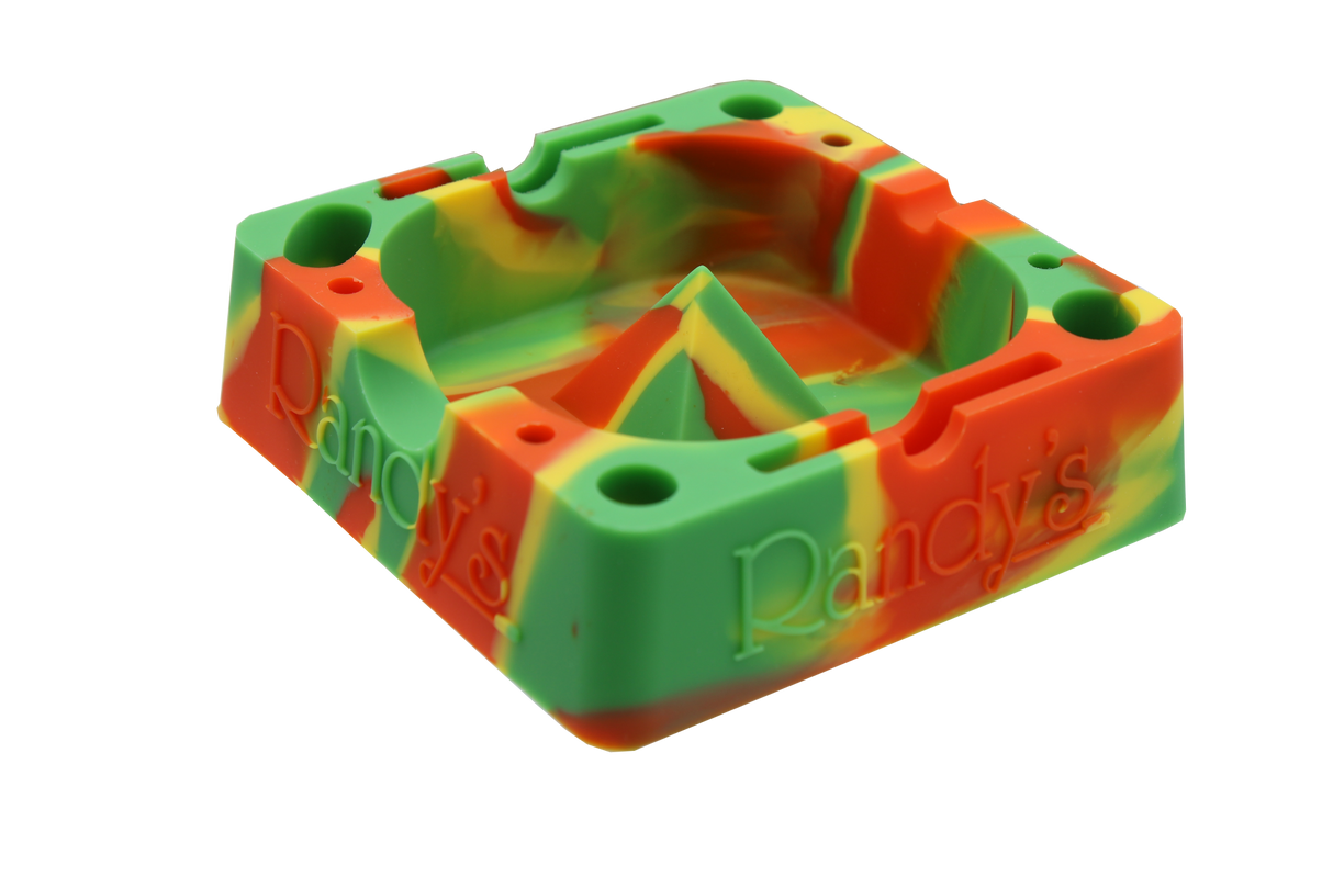 angle view of the Randy's 7" ashtray. A heat resistant and durable ash tray with storage compartments and a debowler spike in the center for ease of cleaning. casted in rasta colors