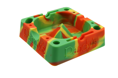 angle view of the Randy's 7" ashtray. A heat resistant and durable ash tray with storage compartments and a debowler spike in the center for ease of cleaning. casted in rasta colors