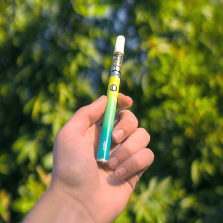 view of ugly slim twist battery in hand with a yellow and aqua gradient known as palm spring.
