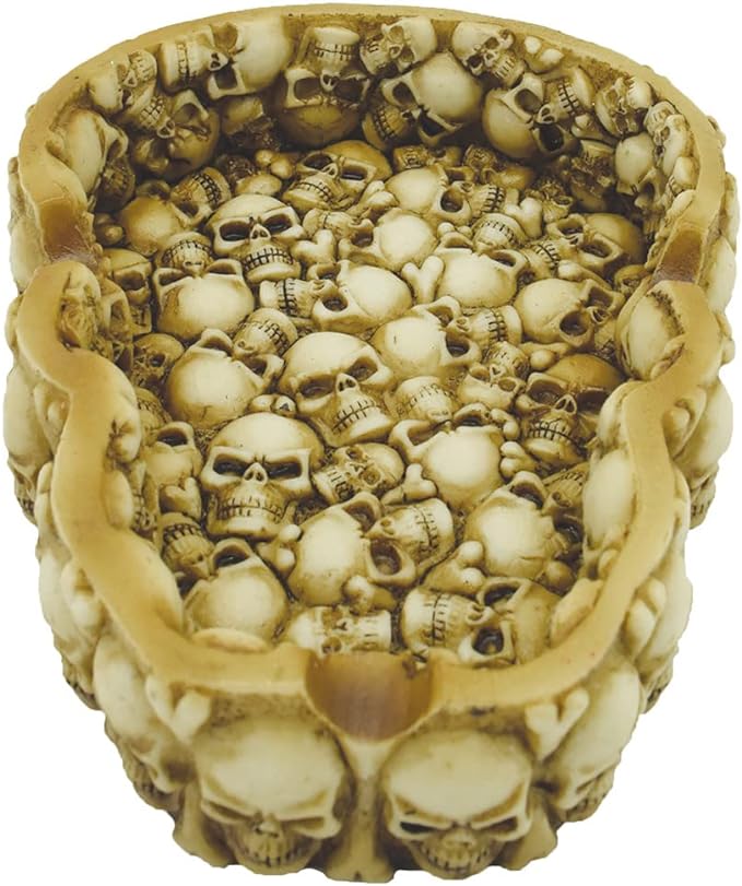 Angled profile view of the assorted design metal ashtray featuring a black and white gothic skull graphic. Crafted from heat-resistant tin, the smooth basin is designed to be easily wiped clean after heavy smoking sessions.