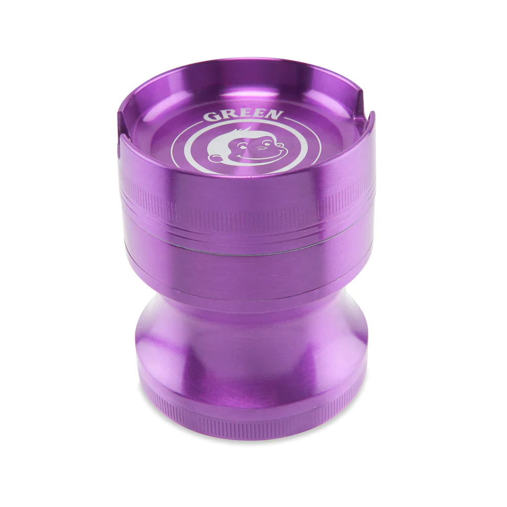 Angled view of the Green Monkey Chacma grinder in deep purple. This durable 63mm 4-piece zinc alloy grinder features a chalice-style shape and a built-in ashtray on the lid for convenience.