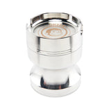 Angled view of the Green Monkey Chacma grinder in sleek silver. This durable 63mm 4-piece zinc alloy grinder features a chalice-style shape and a built-in ashtray on the lid for convenience.