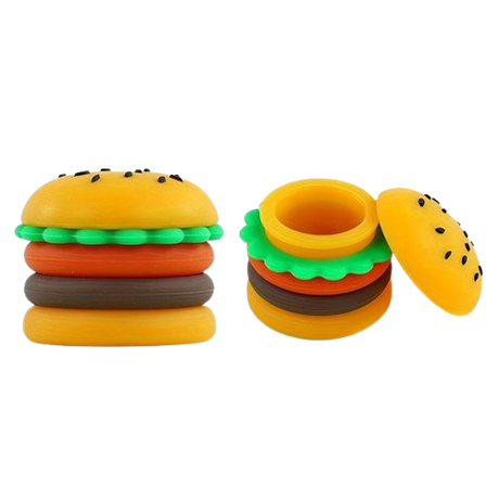 Angled overhead view of the Hamburger silicone wax containers in brown, green, yellow, and red. These 5ml food-themed, residue-repellent extract carriers feature removable modular rings and securely store semi-solid botanical materials.
