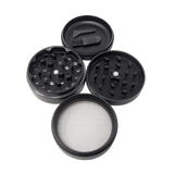 Angled overhead view of the King Palm 62mm aluminum herb grinder in black, disassembled to show its four-piece construction. This highly durable accessory includes a dedicated grinding chamber, a deep flower storage catch, and a fine mesh pollen screen.