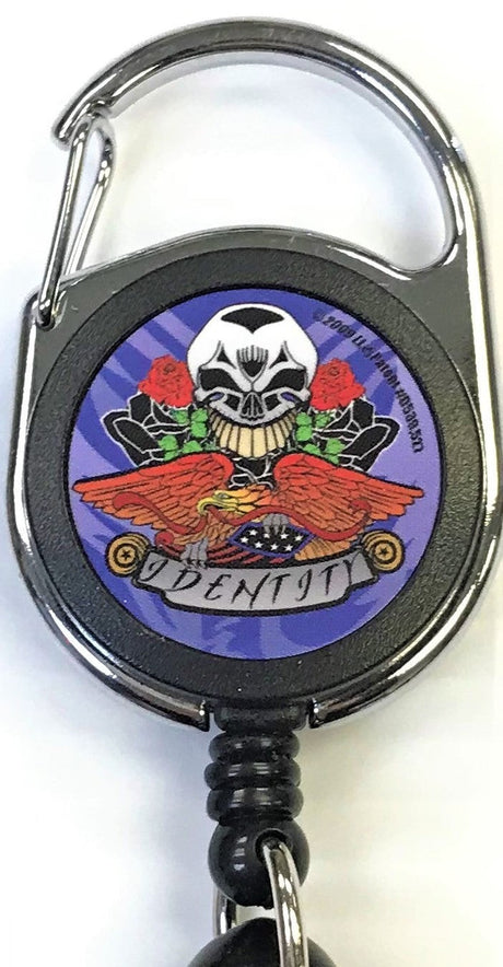 Front facing view of the Merchants Lighter Leash Tattoo Series Holder displaying an assortment of roses with skull and eagle. This highly practical retail companion accessory clips securely to belt loops, keys, or pockets to ensure consumers never lose their lighter.