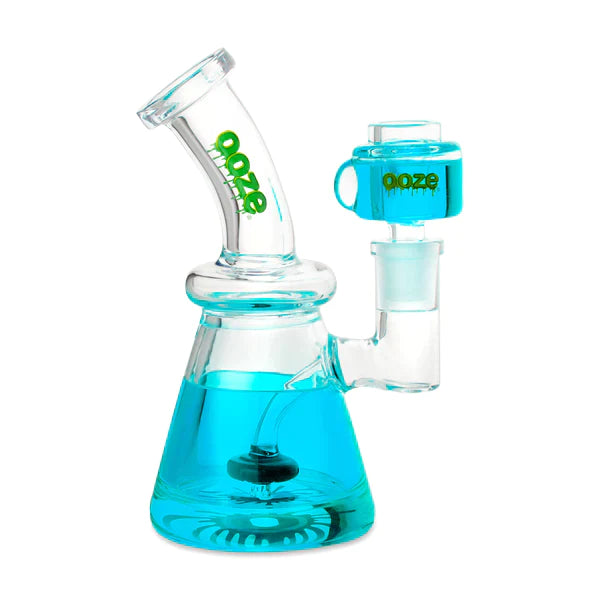 Front view of the Ooze Glyco Glycerin Freezable Water Pipe in teal. This compact 6.5-inch borosilicate glass beaker bong features a hollow base filled with bright green freezable liquid glycerin to deliver incredibly cold, ice-like hits.