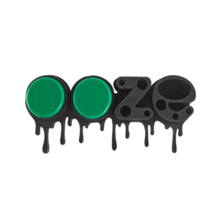 Close-up angled view of the storage slots on the green Ooze Stash Station Silicone Organizer. The flexible, non-stick silicone compartments are designed to firmly grip varied accessory sizes, preventing fragile glass vape carts and glass tools from tipping over.