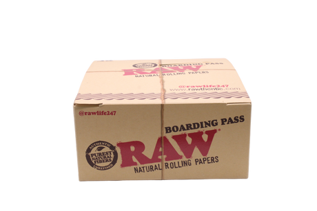 Front view of the RAW boarding pass portable tray display box in natural kraft brown and red. This 15-count retail display offers a travel-friendly metal rolling platform designed to catch loose herbs during on-the-go sessions.