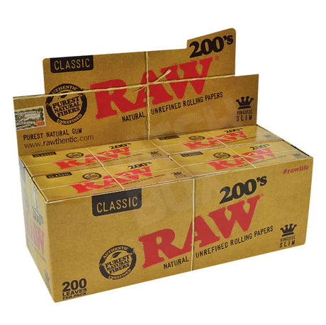 Front angled view of the RAW Classic 200s King Size Slim rolling papers protective slide box in natural kraft brown with bold red and black branding. This rigid box keeps the large stack of unbleached papers perfectly flat and protected from creases while in your pocket or smoking kit.