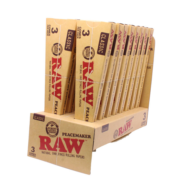 Angled overhead view of the open RAW Peacemaker cones display box revealing the individual 3-packs. The natural unbleached brown wrappers are capable of comfortably holding up to 2.25 grams of ground material.