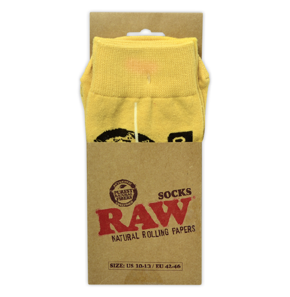 Front view of a pair of RAW knit socks in classic tan featuring the iconic red script brand logo. These officially licensed, lightweight crew socks fit US sizes 10-13 and are designed with an extended snug cuff for daily comfort.