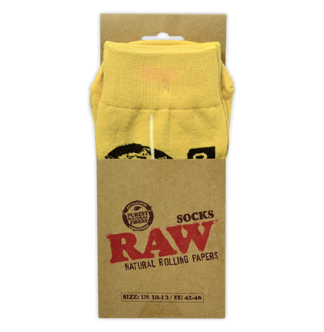 Front view of a pair of RAW knit socks in classic tan featuring the iconic red script brand logo. These officially licensed, lightweight crew socks fit US sizes 10-13 and are designed with an extended snug cuff for daily comfort.