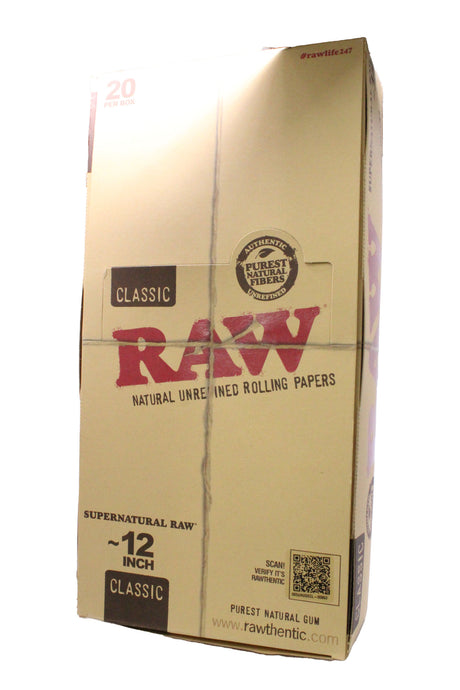 Angled overhead view of the RAW Supernatural 12-inch rolling papers display box showing the brown and red packaging. Crafted from natural unrefined plant fibers, they feature a proprietary criss-cross watermark to ensure a slow, even burn.