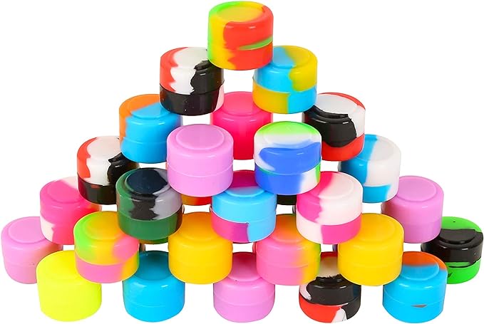 Angled front view of the Silicone Dab Jar 2ml 25ct wholesale clear display tub holding assorted colored jars. These non-stick, food-grade silicone containers are designed for safely storing and transporting sticky plant concentrates and wax.