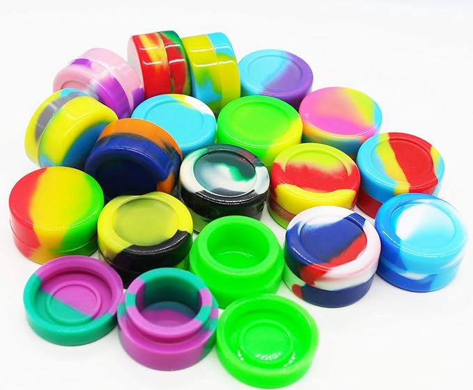 Angled front view of the Silicone Dab Jar 5ml 25ct wholesale clear display tub filled with assorted colors. This bulk package provides a retail-ready point-of-purchase display featuring non-stick, food-grade silicone containers built for storing waxy plant concentrates.