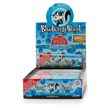 Front view of the Skunk Brand flavored rolling papers 1 1/4 size 24-count display box in a vibrant multicolored aesthetic with the iconic skunk logo. This wholesale countertop display case contains a sweet variety of slow-burning hemp papers designed to take the bite out of harsh herbs.