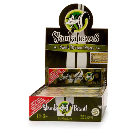 Front view of the Skunk Brand flavored rolling papers 1 1/4 size 24-count display box in a vibrant multicolored aesthetic with the iconic skunk logo. This wholesale countertop display case contains a sweet variety of slow-burning hemp papers designed to take the bite out of harsh herbs.