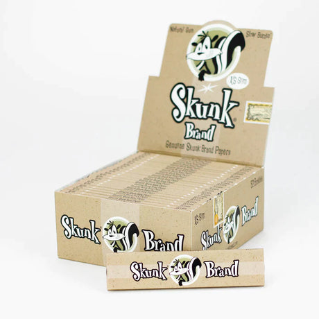 Front view of the Skunk Brand King Size Slim 50 booklets display box in its signature purple and black packaging. This wholesale countertop display case features the iconic Sneaky character logo and holds fifty premium hemp rolling paper booklets.
