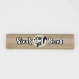 Front profile view of a single Skunk Brand King Size Slim rolling paper booklet showcasing the purple background and black accents. These classic unflavored sheets are made from 100% pure hemp to deliver a clean, smooth, and authentic smoking session.