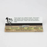 Top down view of an open Skunk Brand King Size Slim booklet revealing the ultra-thin, translucent hemp leaves. Each sheet features a shiny, plant-based vegan acacia gum line designed for a completely chemical-free, secure adhesive seal.