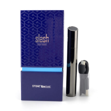 Overhead spread view of the Stone Smiths' Slash Vaporizer Kit components in black, arranged neatly on a flat surface. The complete dab pen kit includes the main device, an extra loading tool, silicone mouthpiece, 6-compartment concentrate container, USB-C charging cable, and a heat protector band.