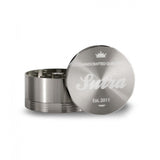 Angled front view of the Sutra Aluminum 4-piece 65mm herb grinder in a polished metallic silver finish. The smooth threading and included pollen scraper make this large 65mm hand crusher incredibly easy to clean and maintain over long-term use.