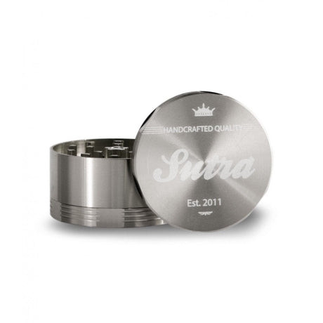 Angled front view of the Sutra Aluminum 4-piece 65mm herb grinder in a polished metallic silver finish. The smooth threading and included pollen scraper make this large 65mm hand crusher incredibly easy to clean and maintain over long-term use.