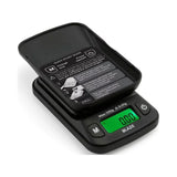 Front angled view of the Truweigh Blaze digital scale in black with its hard plastic cover detached and used as an expansion tray. Both capacity variants feature this dual-purpose lid and a tare function to easily weigh loose materials.