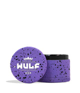 Front angled view of the Wulf 4-Piece 65mm Aerospace Aluminum Grinder in purple with black splatter. Crafted from durable aerospace-grade metal, this large multi-chamber grinder effortlessly shreds dry botanicals to the perfect consistency for rolling or packing.